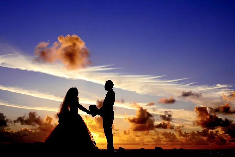 Novios tomados de la mano al atardecer